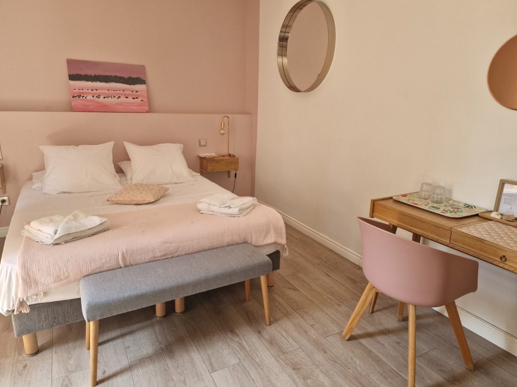 Tidy bedroom with a double bed, desk and wooden floor